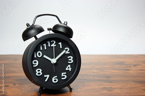 Black alarm clock on wood table