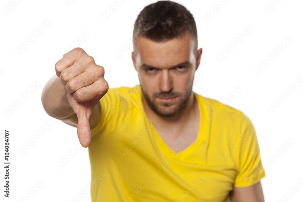 handsome young angry man shows thumb down handsome young angry man shows thumb down