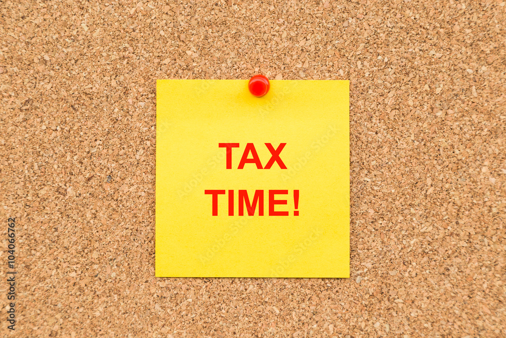Yellow blank note and written TAX TIME for reminder. Yellow blank note and written TAX TIME for reminder.