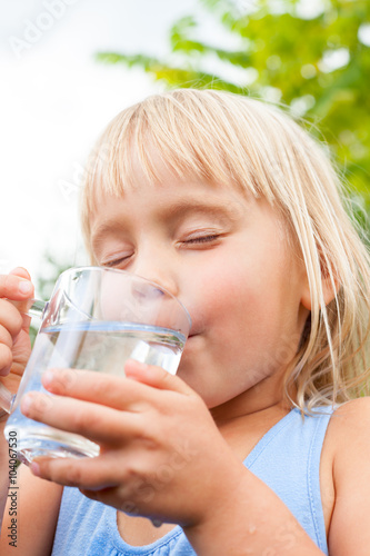 Child enjoy drinking water outdoors