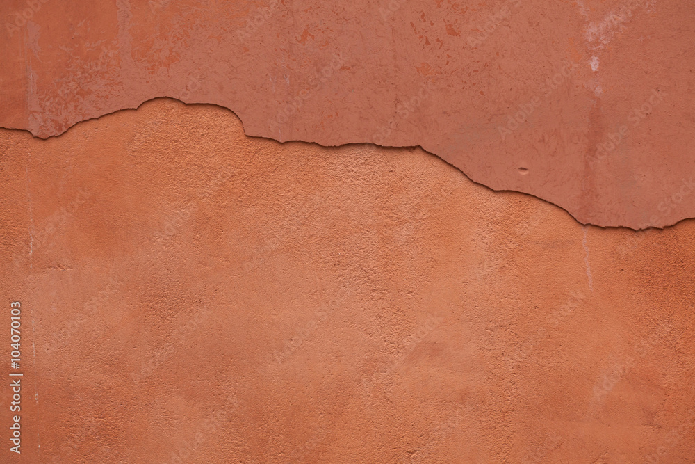 Fototapeta premium Old terracotta painted stucco wall with cracked plaster. Backgro