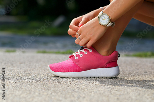 Fototapeta Naklejka Na Ścianę i Meble -  Runner girl tying pink shoes