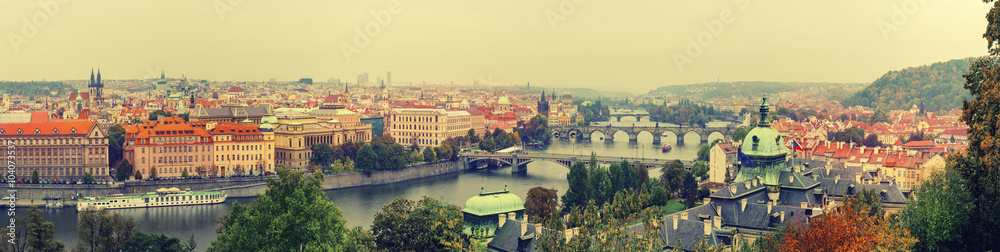 Panoramic view of old beautiful Prague city with red roofs and bridges through the river Vltava, vintage retro autumn hipster background