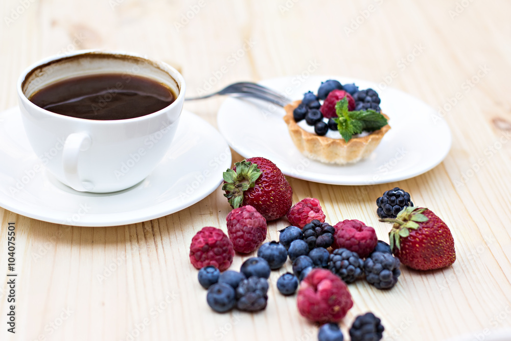 Tart with Fresh berries - dessert on wooden table close up Tart with Fresh berries - dessert on wooden table close up
