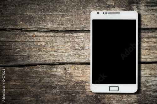 Smart phone with white screen isolated on a black wooden table