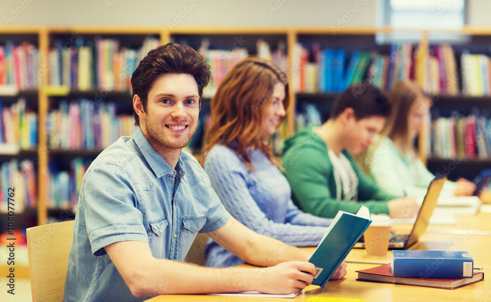 happy student boy reading books in library happy student boy reading books in library