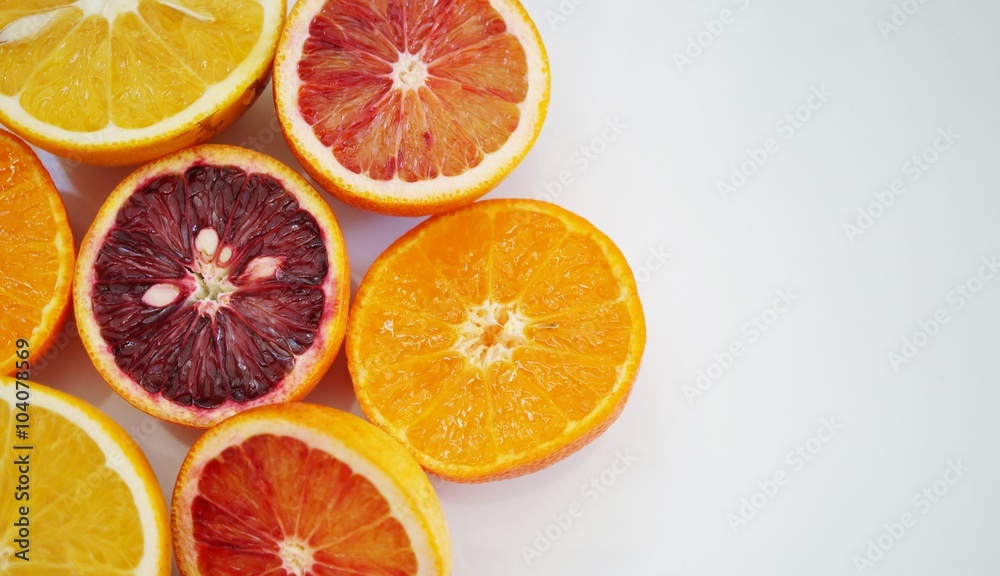 Ruby red blood oranges, navel oranges, and clementines cut in half on a white platter Ruby red blood oranges, navel oranges, and clementines cut in half on a white platter