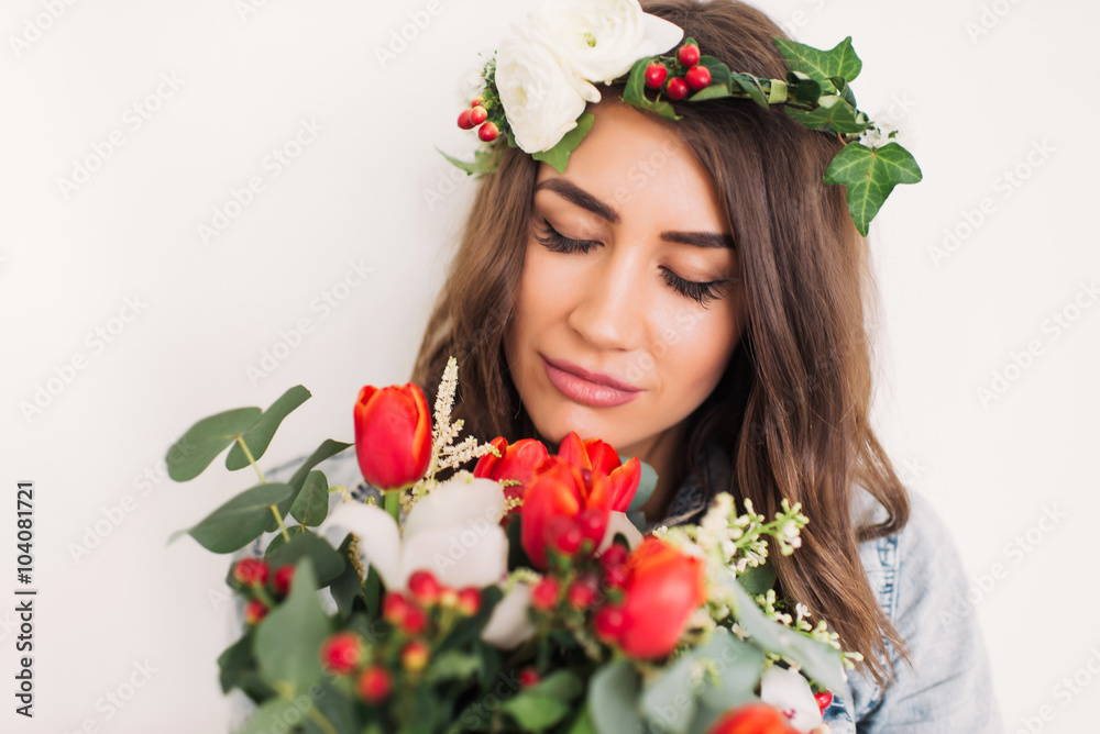 beautiful young girl in jeans jacket with a bouquet of flowers from tulips and a wreath of flowers on a white background, portrait beautiful young girl in jeans jacket with a bouquet of flowers from tulips and a wreath of flowers on a white background, portrait