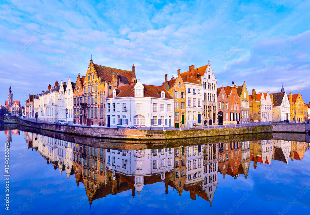 Cityscape view of Bruges and traditional houses reflected in water at sunrise in Belgium