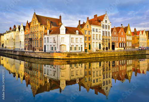 Traditional architecture in Brugge town reflected in water at dusk in Belgium