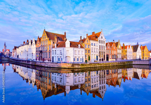 Cityscape view of Bruges and traditional houses reflected in water at sunrise in Belgium photo