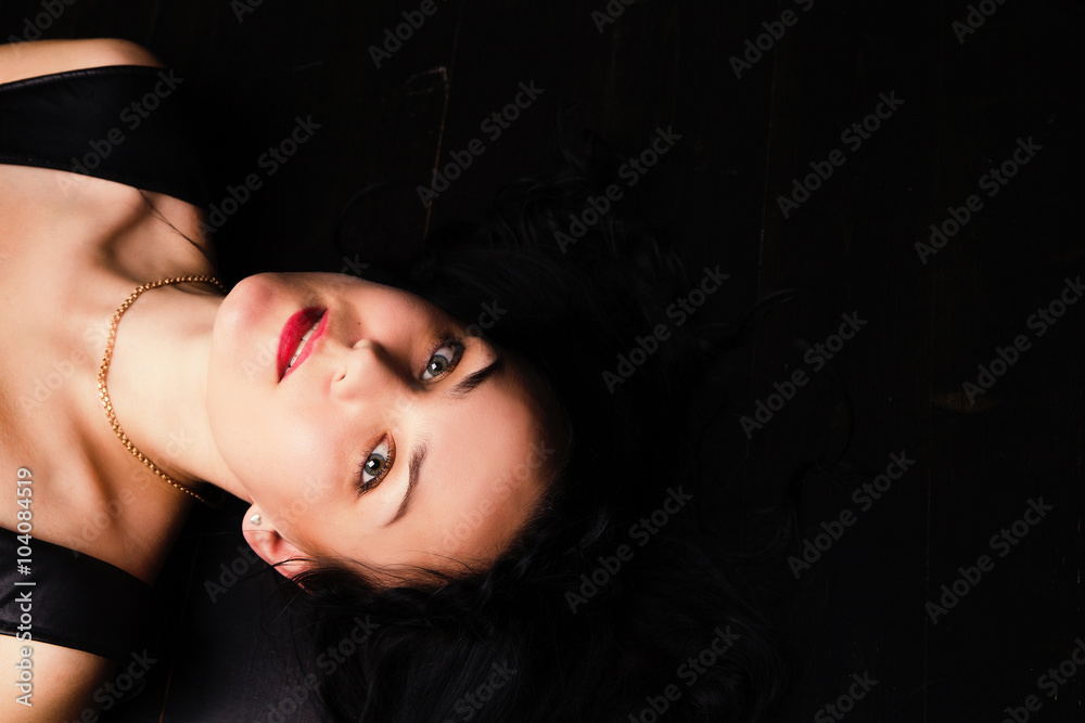 Portrait of a beautiful glamorous brunette lying on the floor in studio Portrait of a beautiful glamorous brunette lying on the floor in studio