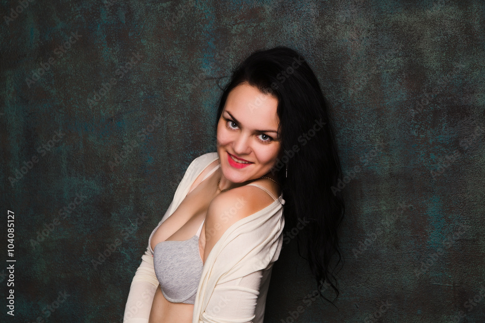 Studio portrait of a sexy brunette in grey lingerie and white cardigan