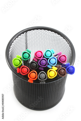 Colored markers in basket on the white background