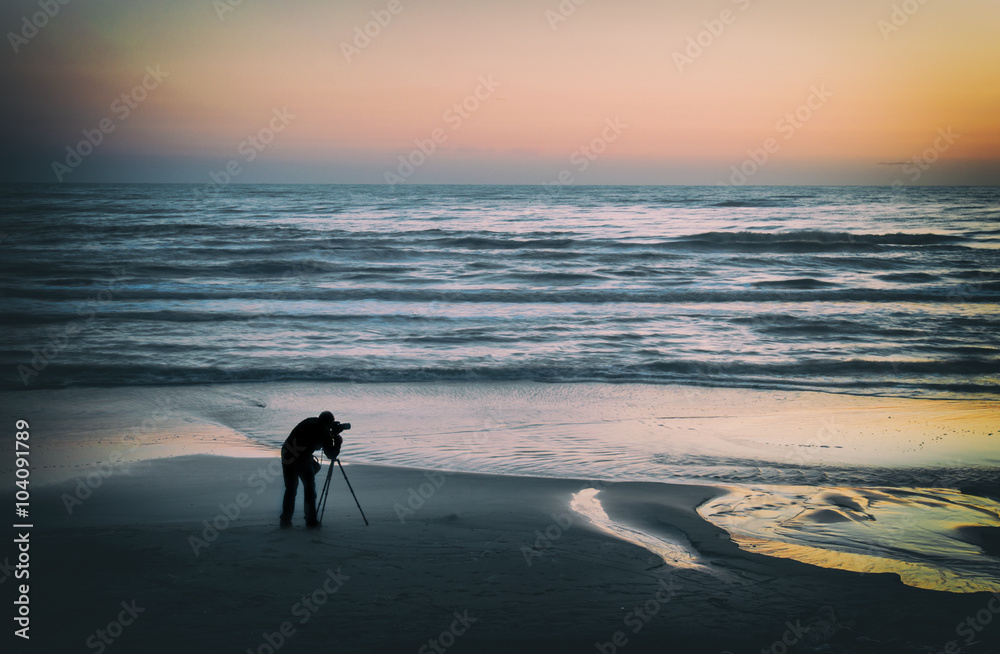 Naklejka premium Silhouette of the photographer on the seashore