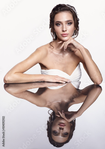 Portrait of young beautiful brunette woman sitting at mirror tab