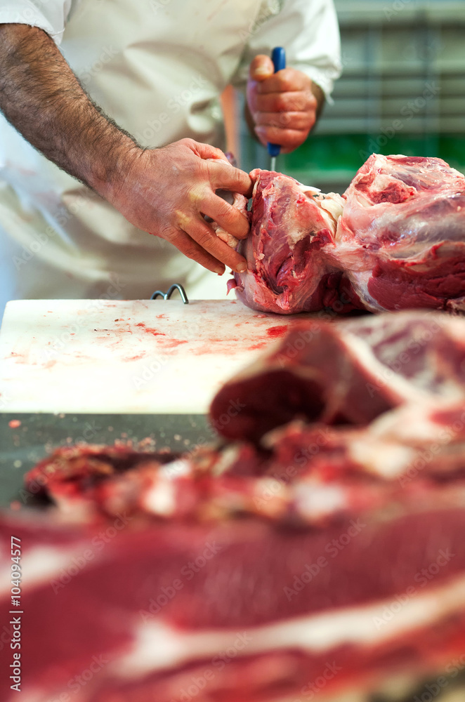 Butcher cutting up raw meat in a butchery