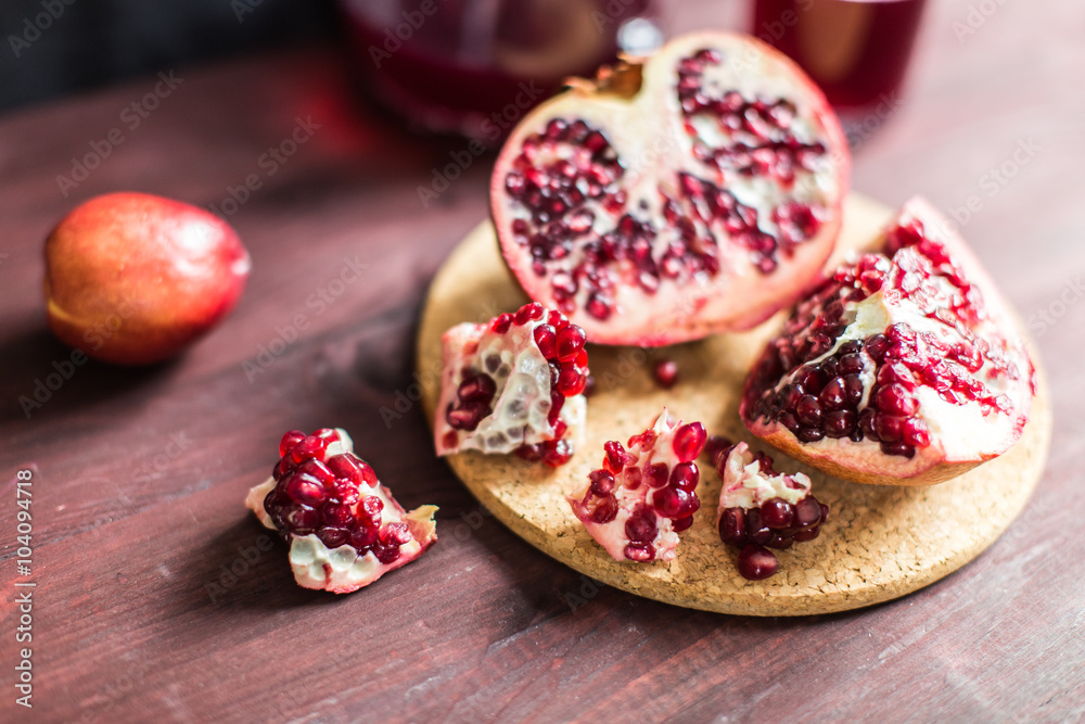 Pomegranate slices and garnet fruit seeds on table Pomegranate slices and garnet fruit seeds on table