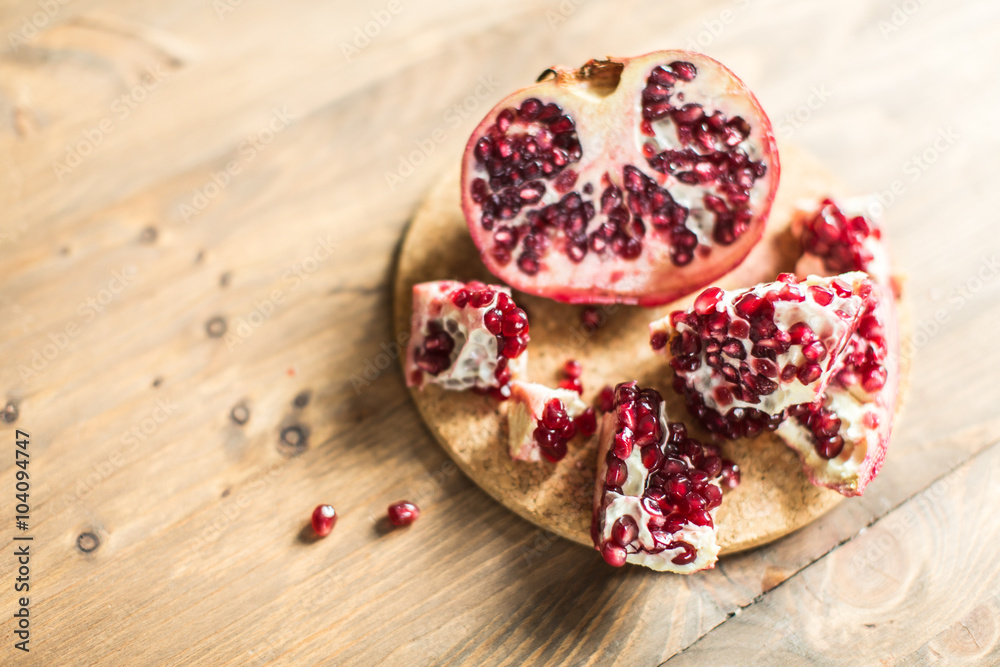 Pomegranate slices and garnet fruit seeds on table Pomegranate slices and garnet fruit seeds on table