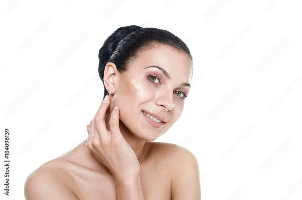 Beautiful face of young woman with cosmetic foundation on a skin