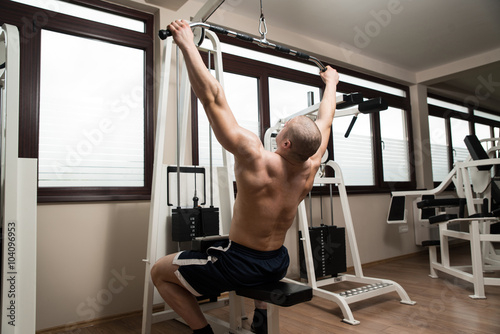 Young Man Doing Back Exercise on a Machine