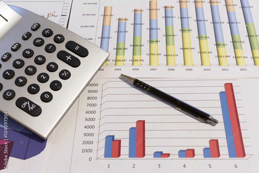 An office desk with charts and histograms graphical documents An office desk with charts and histograms graphical documents