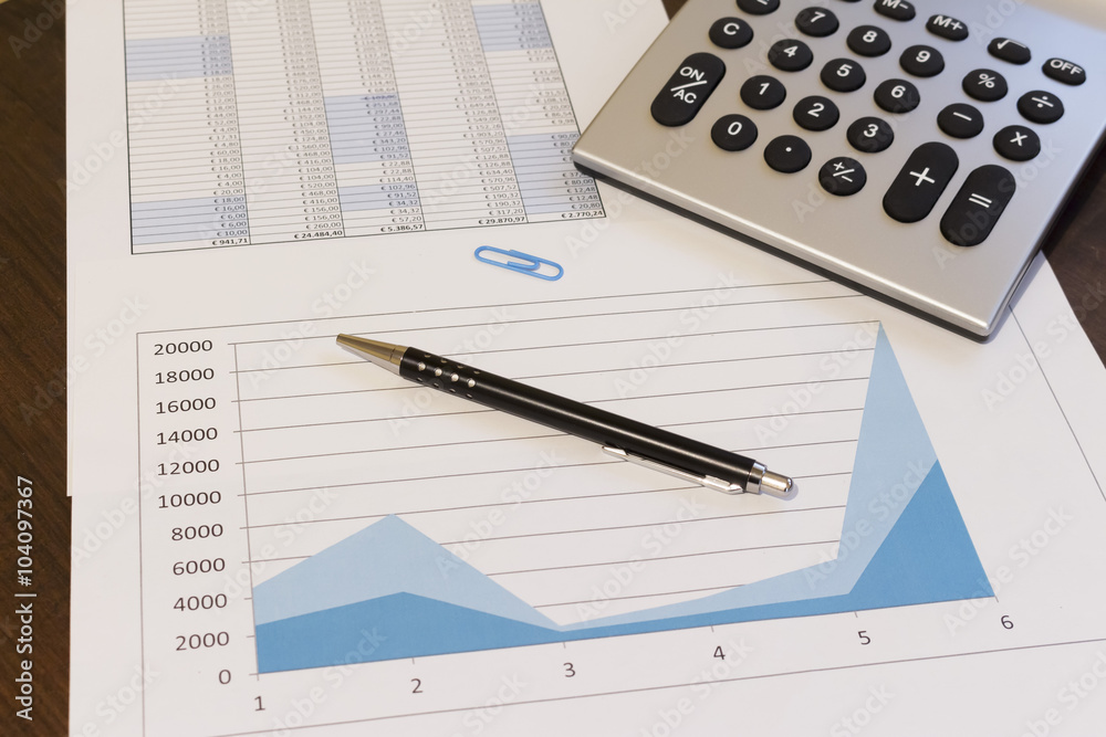 An office desk with charts and histograms graphical documents An office desk with charts and histograms graphical documents