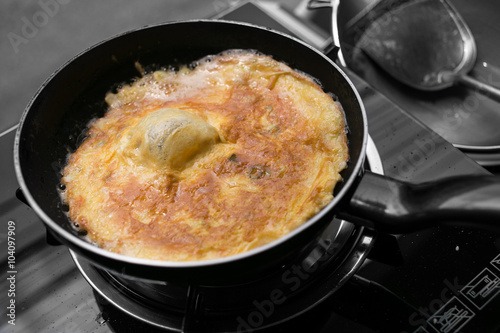 Deep frying egg omelette isolated in Black and White Background.