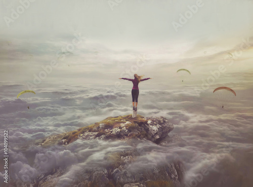 Young woman in the sky standing on a rock with divorced hands