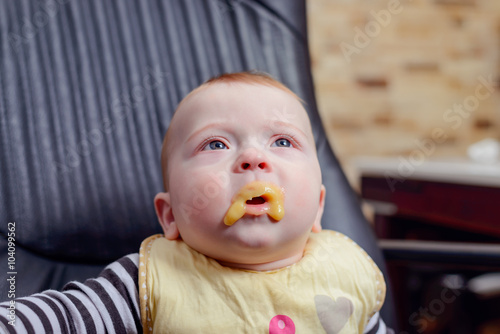 Baby with Food around his Mouth Sitting on Chair