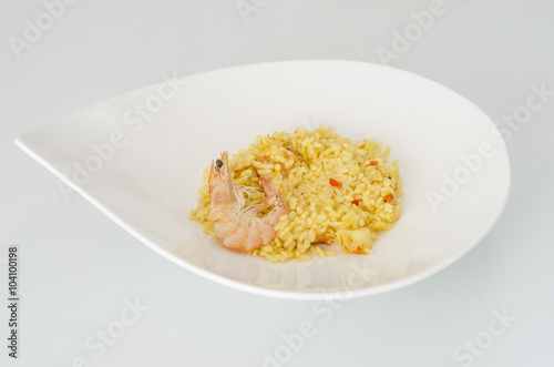 Paella, typical Spanish dish on white background.