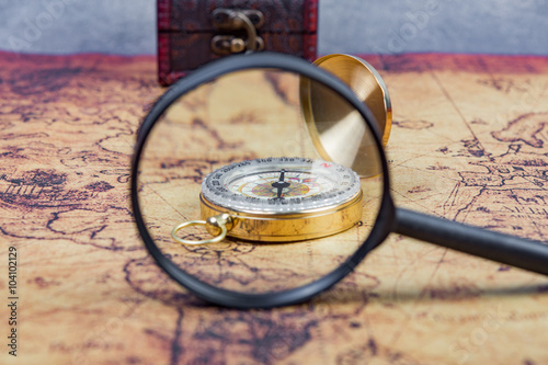 Magnifying glass  focus on compass in Treasure Map