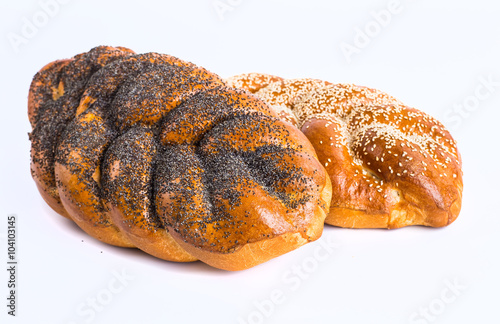 Two whole fresh challah bread with poppy and sesame seeds on a w © bukhta79