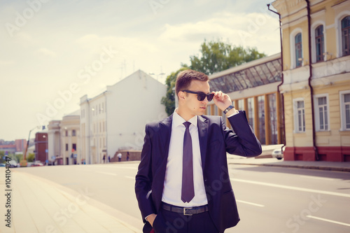 Stylish businessman in the sunglasses near building