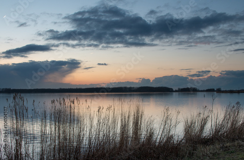 Blauwe uurtje na zonsondergang in het Twiske reacreatiegebied met spiegelend meer