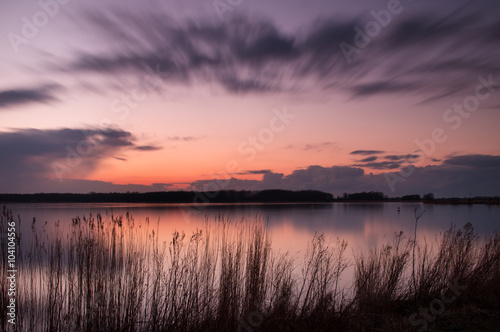 Zonsondergang in het Twiske reacreatiegebied met spiegelend meer © www.kiranphoto.nl