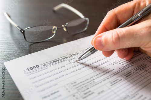 Tax form 1040 for individual tax return with pen and glasses