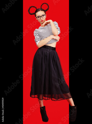 High fashion girl in the glasses with unusual hairstyle like Minnie Mouse in the studio