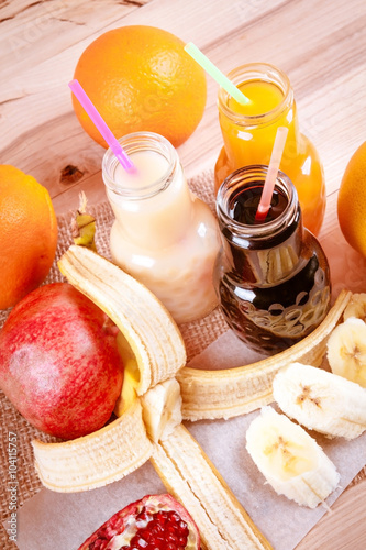 Juice bottle on a wooden background with fruits © vitylia7