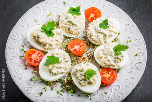 Deviled eggs with mushrooms, mayonnaise and cherry tomatoes on cress sprouts