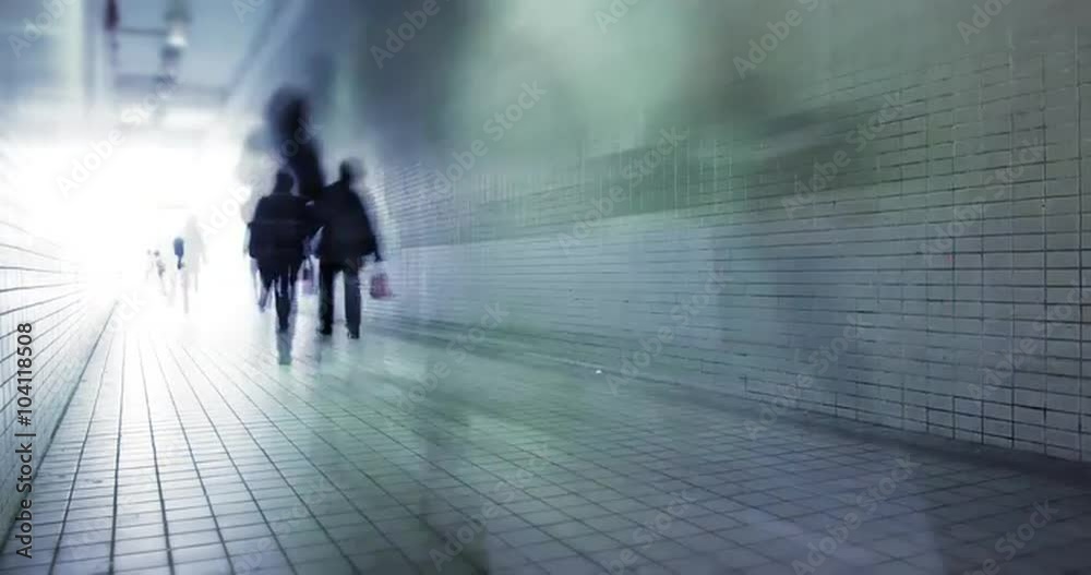 People walk through long tunnel with bright light at the end. City rush concept