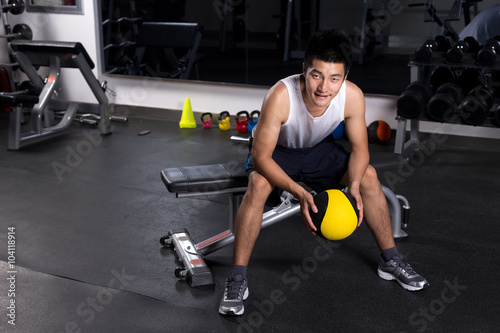 handsome young man working out in modern gym