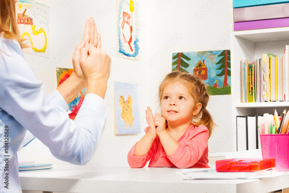 Girl playing finger games with teacher Girl playing finger games with teacher