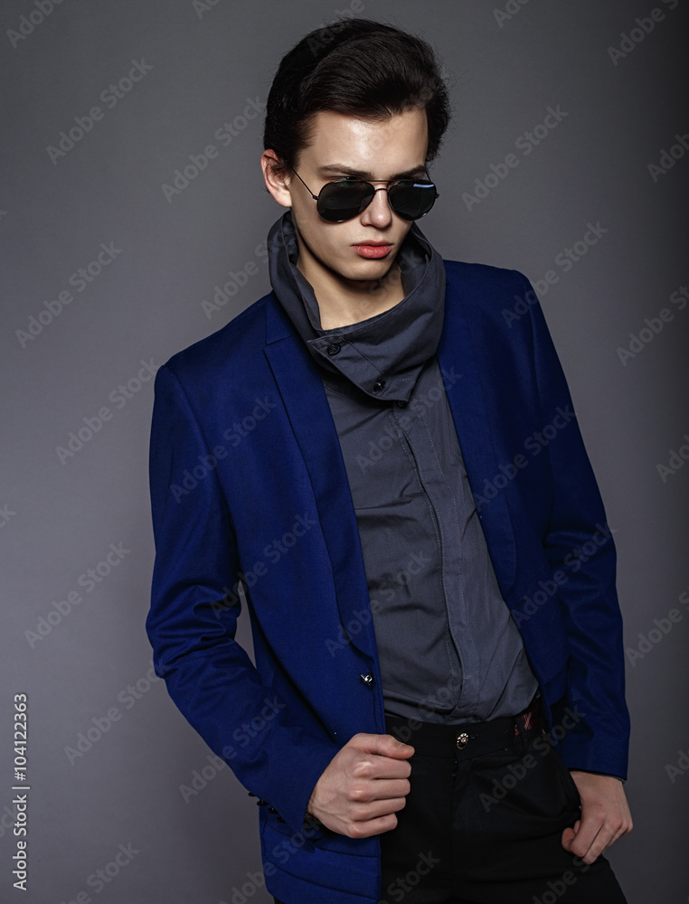 Obraz premium Vogue handsome man in the jacket and sunglasses in the studio