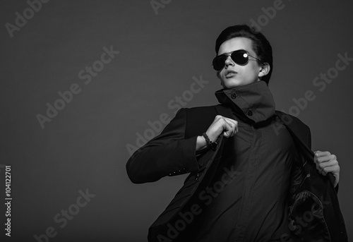 Fotografie Vogue handsome man in the jacket and sunglasses in the studio