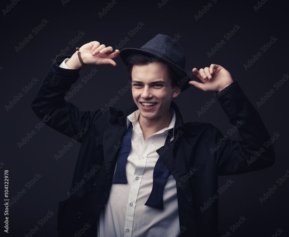 Vogue handsome man in the hat and untied tie bow in the studio portrait