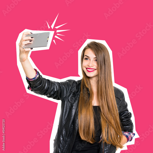 Millennial teenage girl smiling taking a selfie on smartphone photo