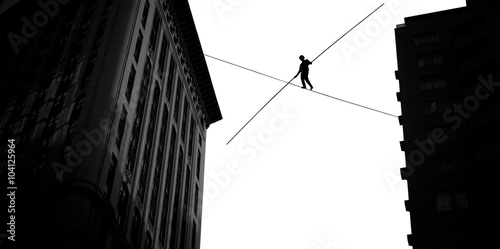 Man balancing on the rope high in the sky photo