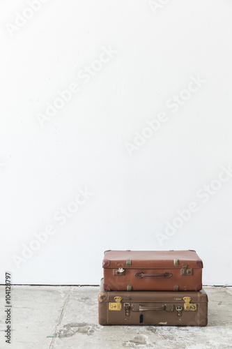 leather suitcase on white wall.