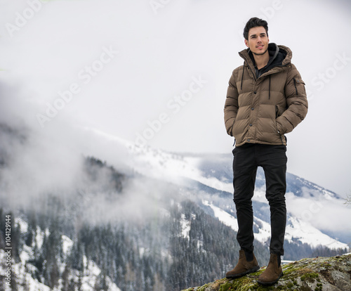 Man in outerwear sitting while looking at camera
